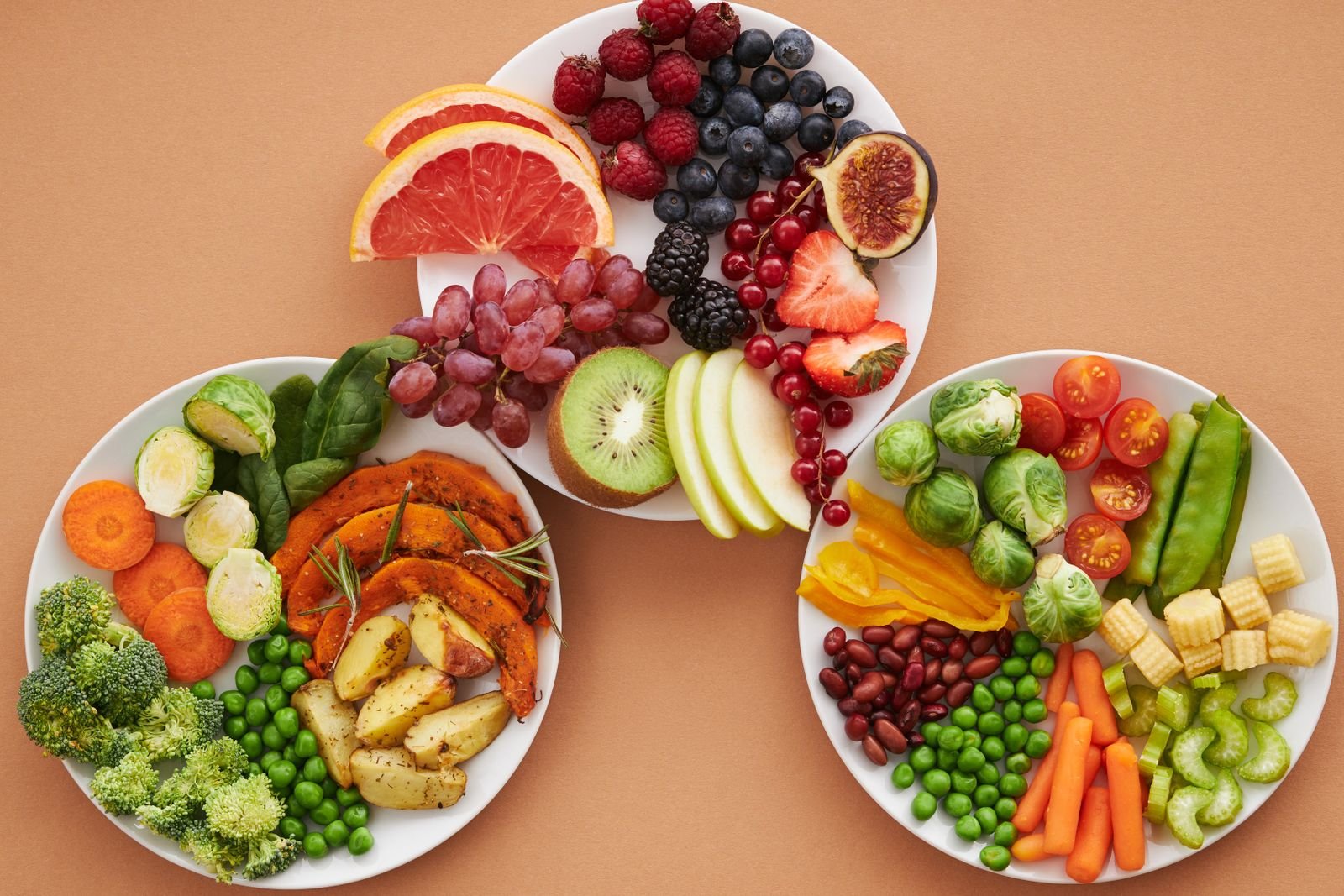 Pratos com frutas e vegetais variados representando alimentação saudável