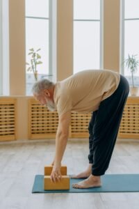 Homem mais velho praticando exercício de alongamento e fortalecimento em tapete, representando cuidado abdominal seguro para prevenção de hérnia paraestomal