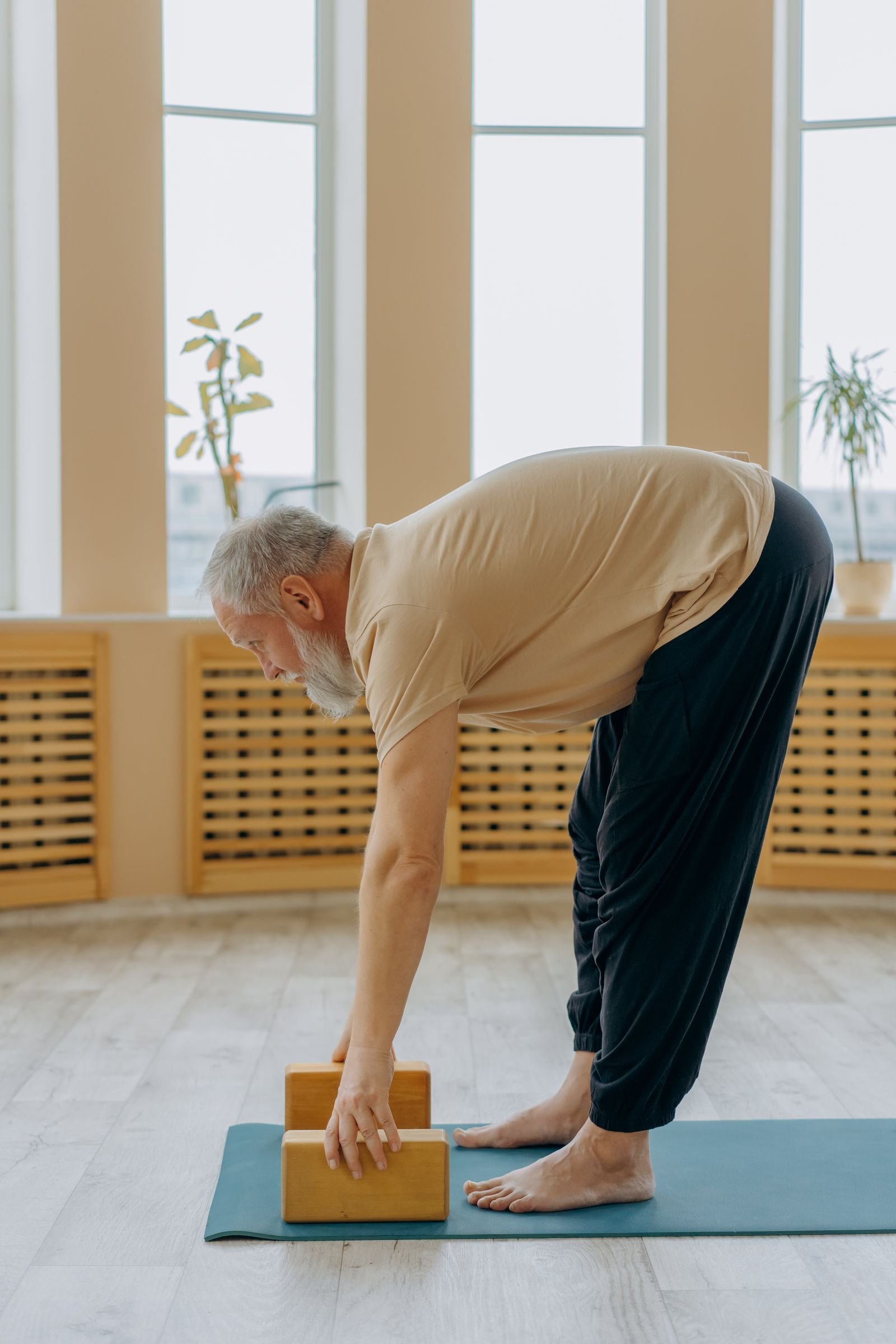 Homem mais velho praticando exercício de alongamento e fortalecimento em tapete, representando cuidado abdominal seguro para prevenção de hérnia paraestomal
