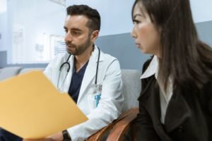 Médico conversando com paciente durante consulta sobre cuidados de saúde